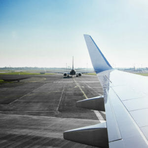 Airplanes on airport runway against blue sky